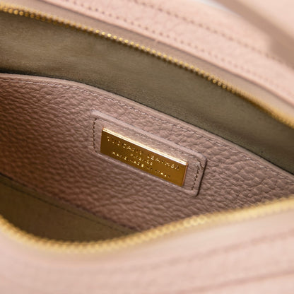 Primer plano of rosa suave piel granulada interior with a gold metal nameplate on a Hoblò hobo bag
