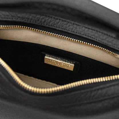 Interior close up of the black Hoblò bag showing the cremallera dorada and a placa de logo dorada on the lining