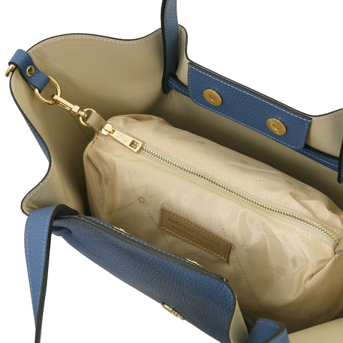 Bege forro interior of blue Legame bag with bolso com fecho and Tuscany Leather label.