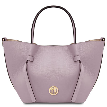 Vista frontal of lavanda Legame leather handbag with asa superior and emblema dorado on the front