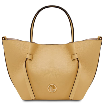Amarillo mostaza Legame leather handbag with asas superiores and a circular placa de logo dorada.