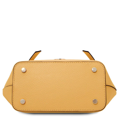Vista inferior of Legame small yellow leather handbag with four metal studs.