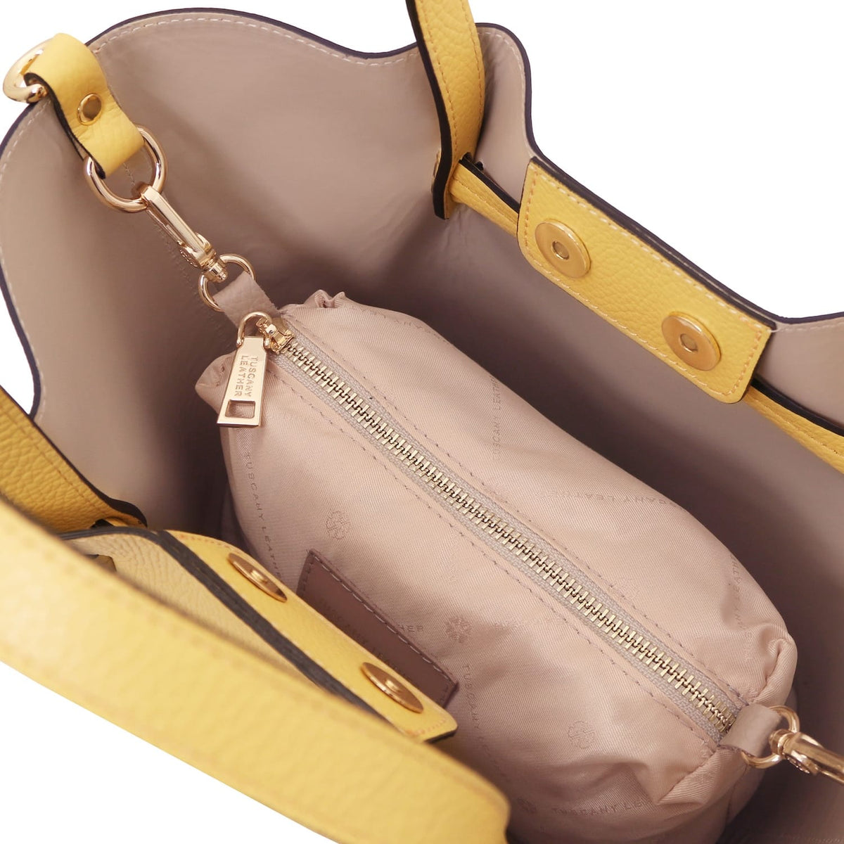 Vista interior of Legame small handbag showing forro beige and a beige zip pouch inside.