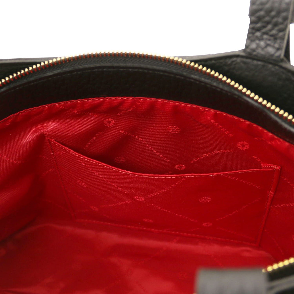 Interior close up of Libra tote featuring red lining and stitched pocket.