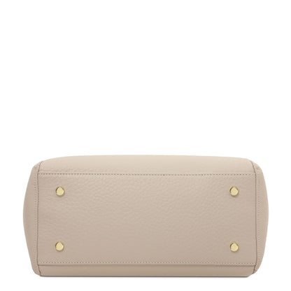 Bottom view of beige pebbled leather Libra tote with four gold studs