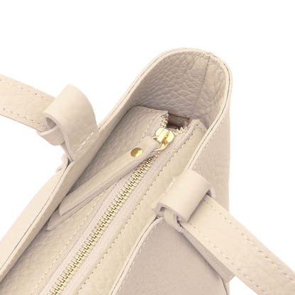 Interior view of beige Libra tote with tan lining, zip pocket and gold nameplate