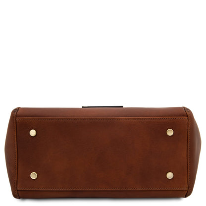 Bottom view of brown Libra leather tote showing four gold-toned studs and stitching.