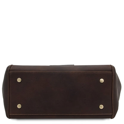 Bottom view of dark brown Libra tote showing gold metal feet and stitched edges