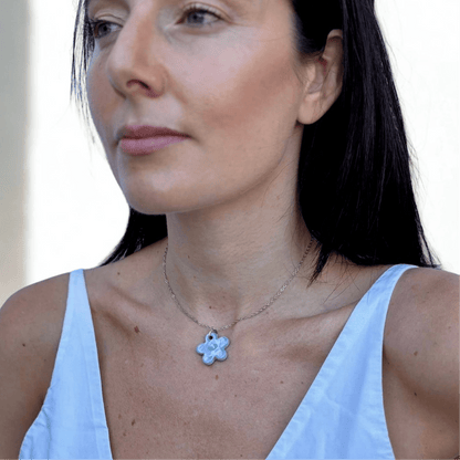 Lillium hellblau floral ceramic necklace von einem Model getragen with the pendant resting at the collarbone