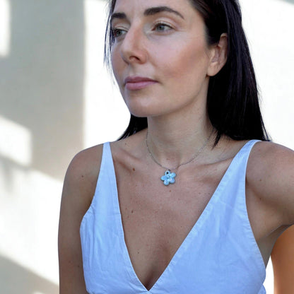 Nahaufnahme of a Frau trägt a handcrafted pearl hellblau floral ceramic pendant necklace