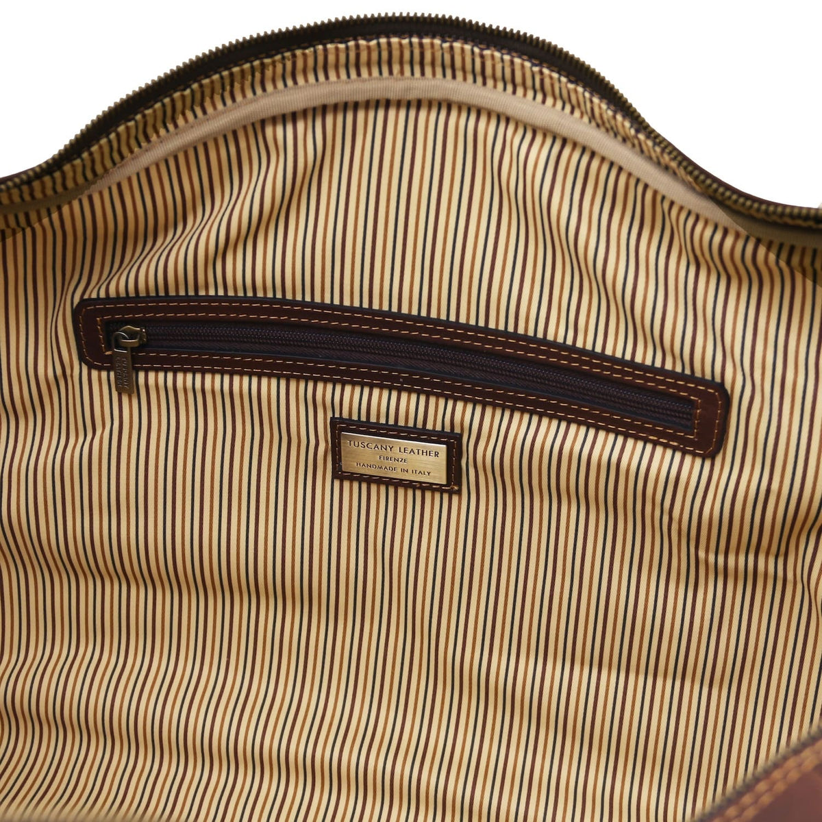 Interior close up showing a poche zippée with dark leather trim on striped lining.