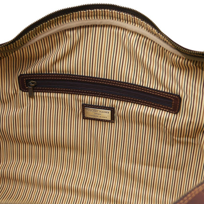 Interior close up showing a poche zippée with dark leather trim on striped lining.