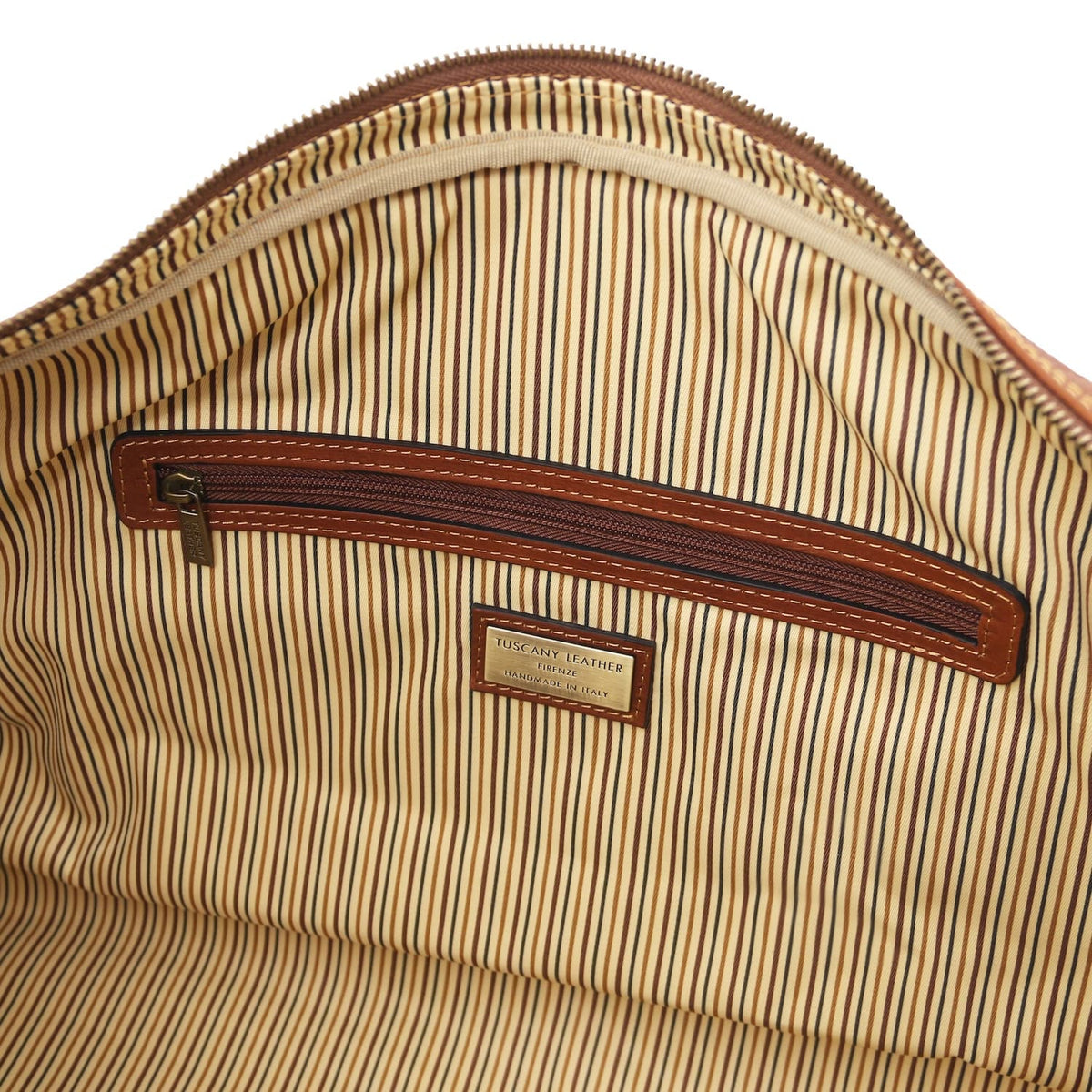 Interior close up with striped lining brown leather poche zippée and metal tag.