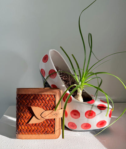 Lumi - Hewoven Leather Wallet | Taupe & Caffè featuring woven leather texture con smooth taupe leather trim beside a bianco planter con rosso dots e verde plant