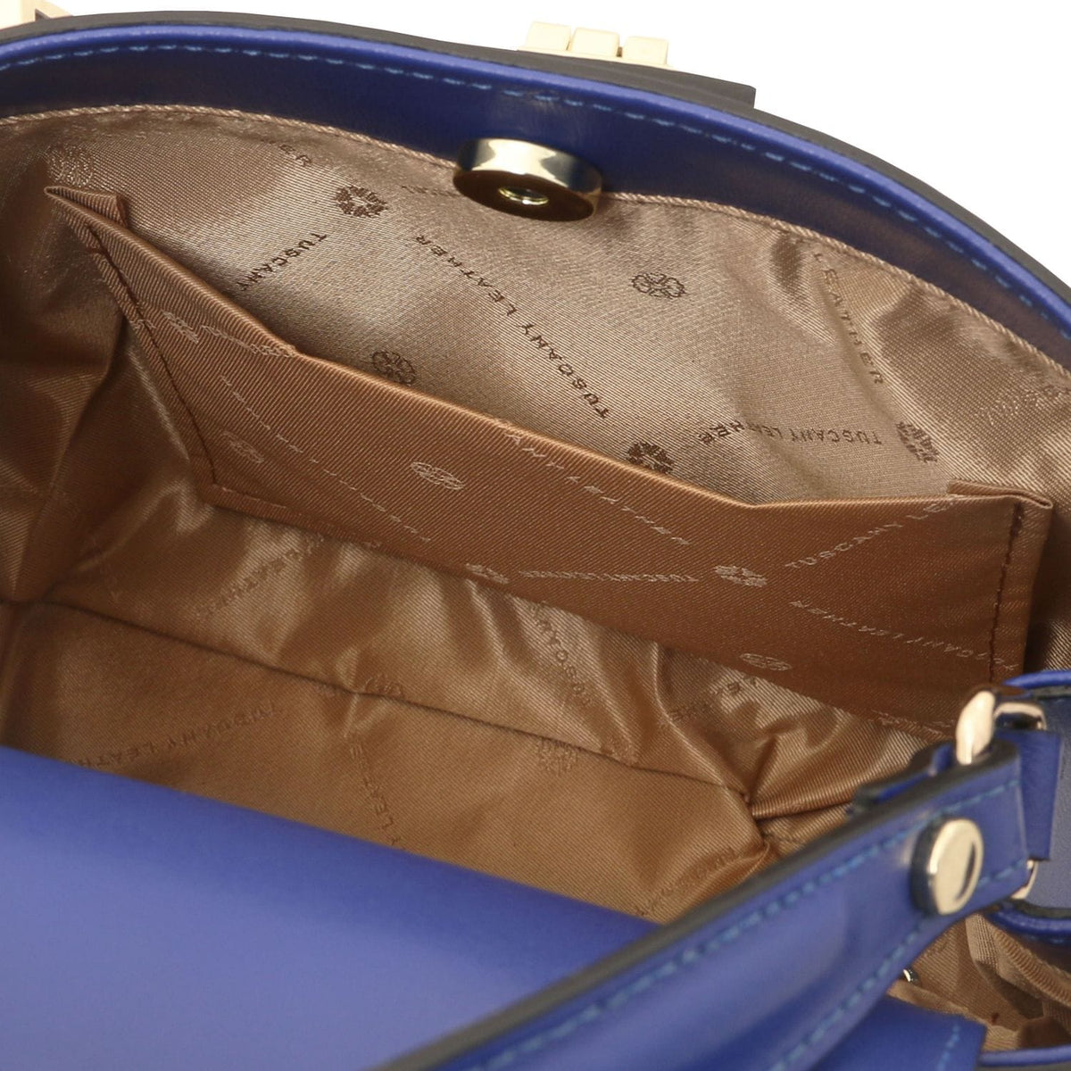 Inside of blue Maisy top handle bag with tan lining, zip pocket and stitched panel