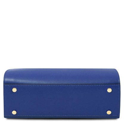 Three quarter view of Maisy blue leather top handle bag highlighting structured silhouette and gold hardware