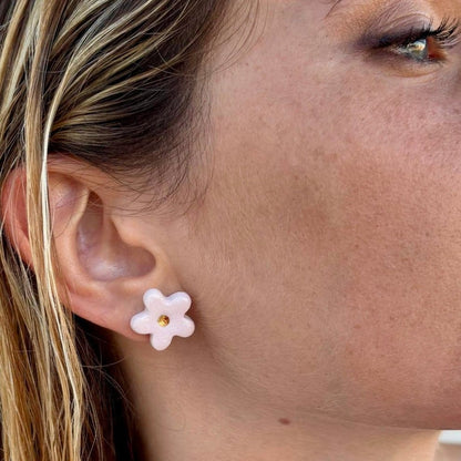 Roze floral ceramic stud earring with gold center worn on the ear