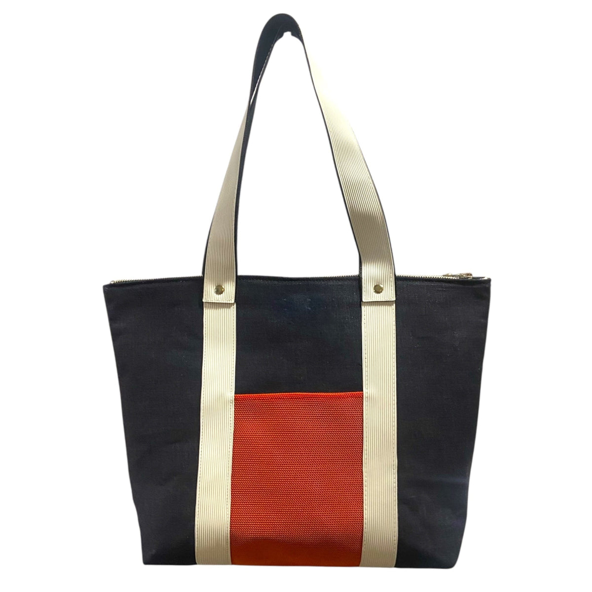 Navy denim tote bag with red pocket and beige handles on a white background