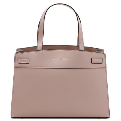 Nude pink handbag with 'Tuscany Leather' branding sobre fondo blanco