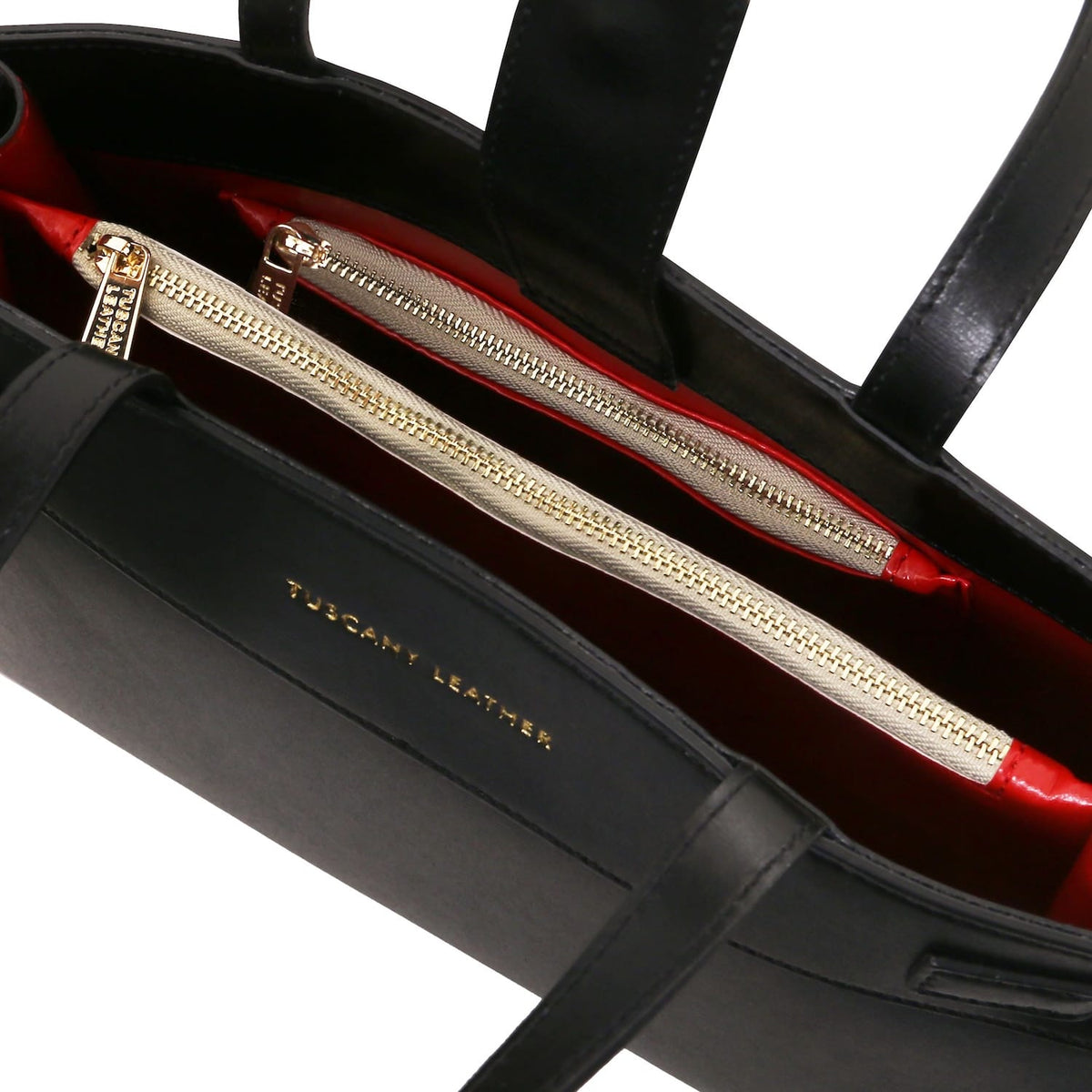 Vista interior of Musa Bolso de piel italiana with red lining and gold zip compartments