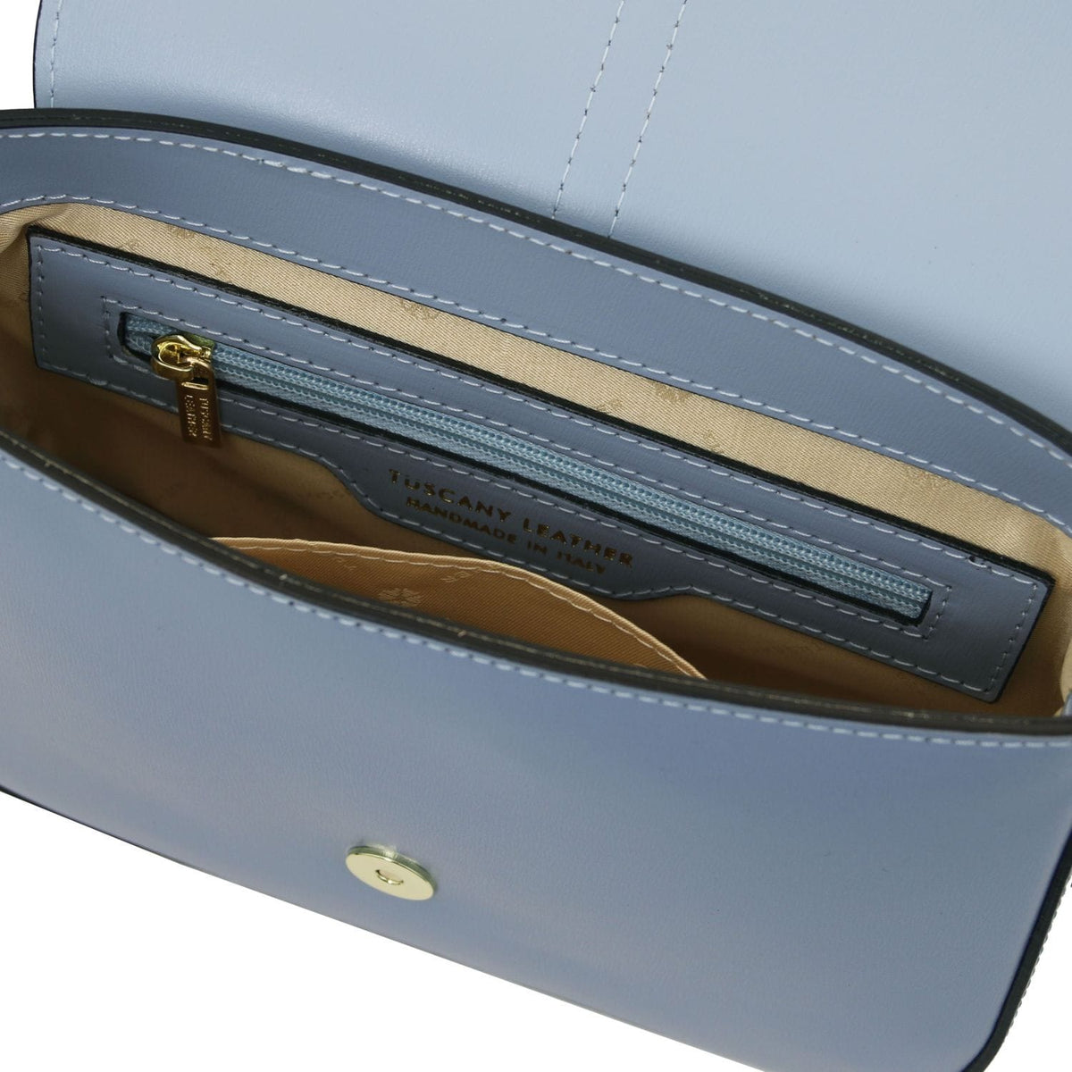 Vista interior of Nausica bag showing forro beige and a blue bolsillo con cremallera with gold pull