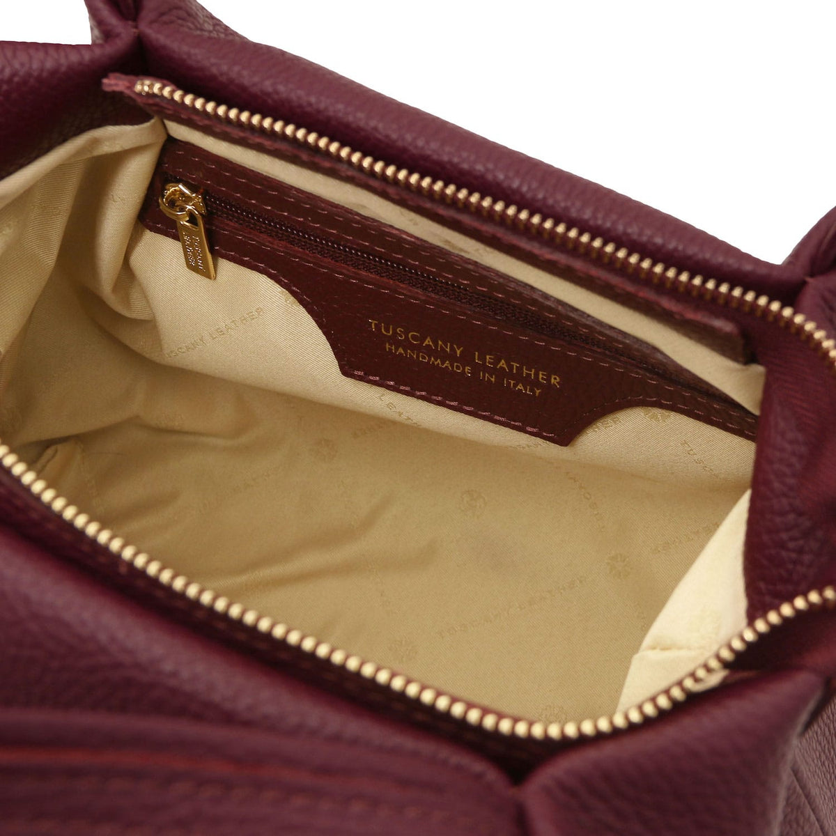 Nora - Soft leather handbag | TL142372 in burgundy pebbled leather with interior zip pocket and beige fabric lining on white background.