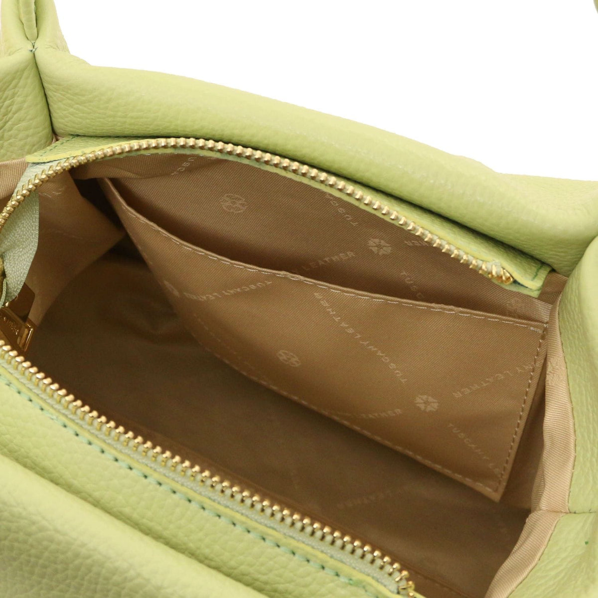 Open view of light green soft leather handbag showing beige fabric interior lining with stitched pocket and gold zipper detail.