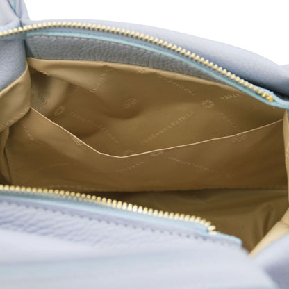 Inside view of the light blue Nora handbag showing tan lining and a back zip pocket along the top edge