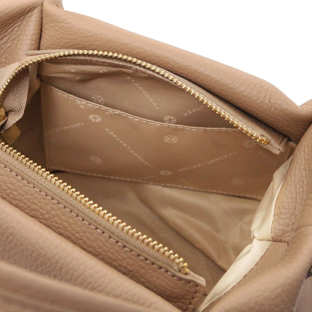 Beige Nora handbag interior with a red zip pocket and brand plaque inside.