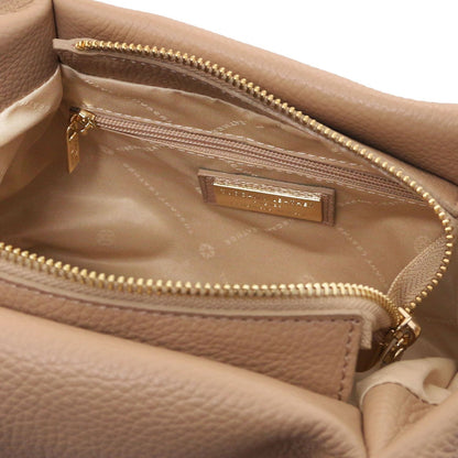 Inside view of beige Nora soft leather handbag showing a zip pocket and gold brand plaque.