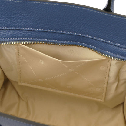 Abierto view of blue leather tote mostrando beige fabric interior pocket with subtle branding and detailed stitching inside zippered compartment.
