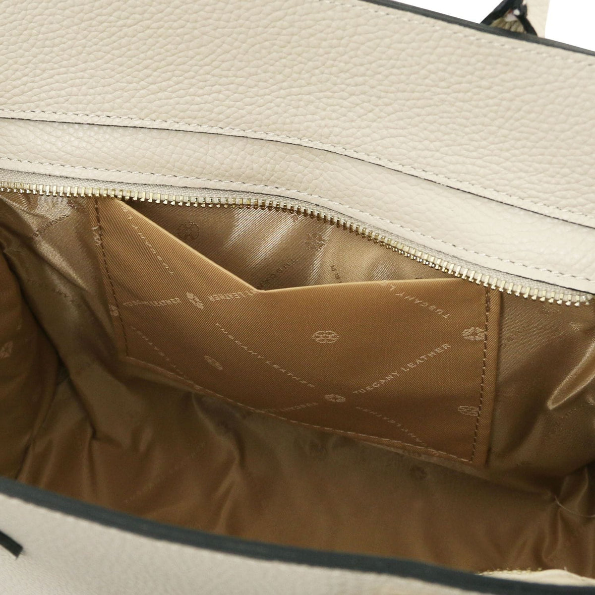 Interior of beige leather tote with forro color cuero and a bolsillo con cremallera
