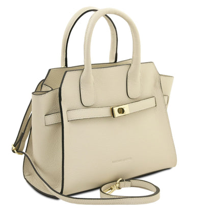 Beige piel granulada tote with dos asas superiores, black edge trim, front strap with gold clasp, and a correa de hombro extraíble