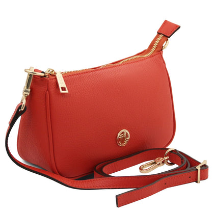 Red textured leather clutch with gold hardware and detachable strap on a white background