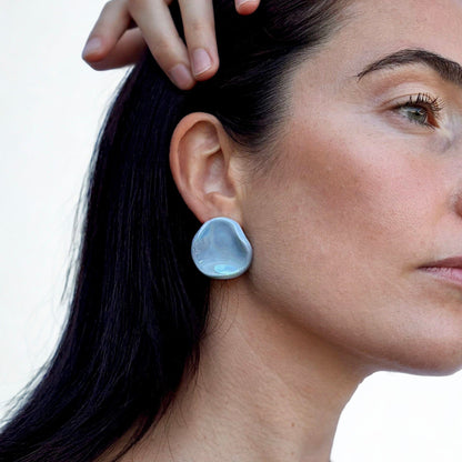 Perla azzurro ceramic stud earring worn on the ear by a model