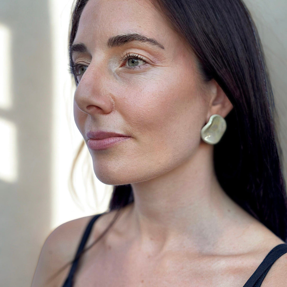Profile view of a donna con the sage-verde ceramic stud earring