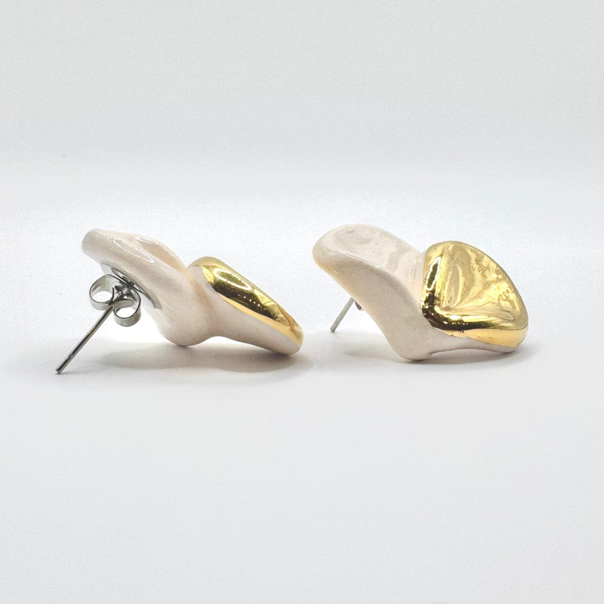 Back view of Petali white ceramic stud earrings with gold luster showing posts