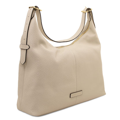 Vista lateral of beige textured Plenia leather bag mostrando the pebbled surface and cremallera dorada along the top