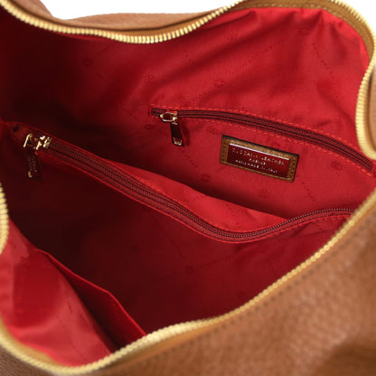 Vista interior with red lining and a bolsillo con cremallera inside the bag.