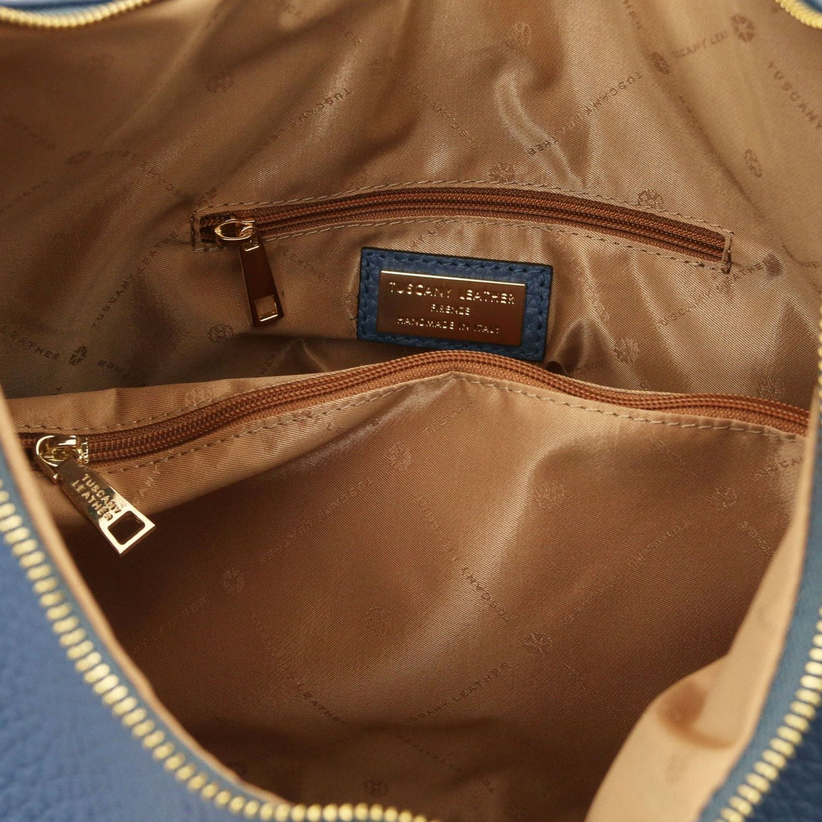 Interior of blue Italian leather bag with forro color cuero and bolsillo con cremallera with branding plaque