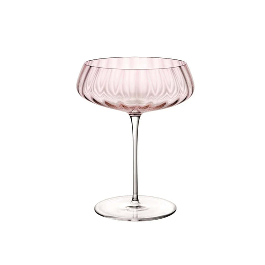 Dusty rose coupe glass with a wide shallow bowl and vertical ridges against a white background