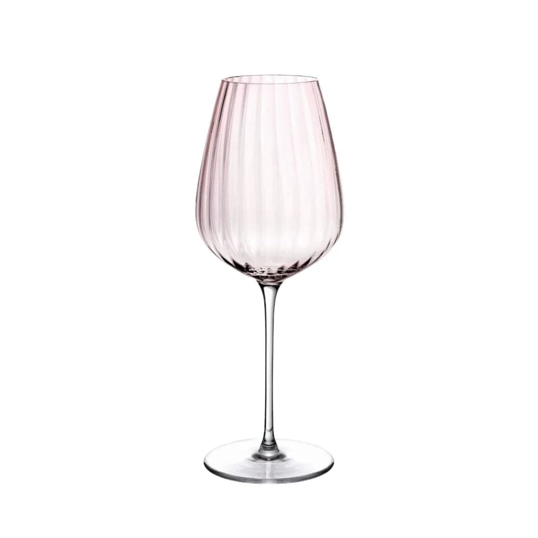 Dusty rose ribbed white wine glass with a long slender stem against white background