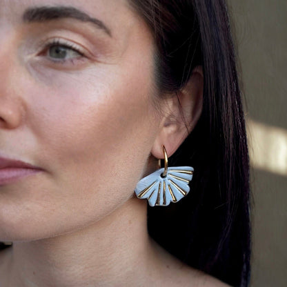 Mulher com azul-claro fan shaped ceramic earrings with gold detailing