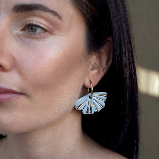 Mujer con azul claro fan shaped ceramic earrings with gold detailing