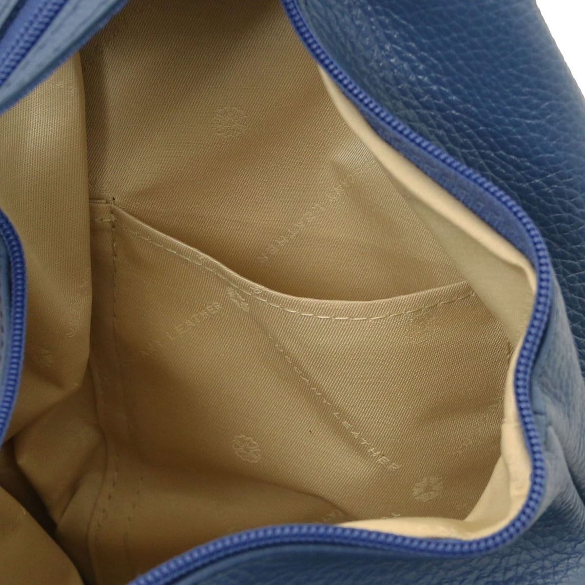 Primo piano of the interior pocket area of the blu backpack con fodera beige.