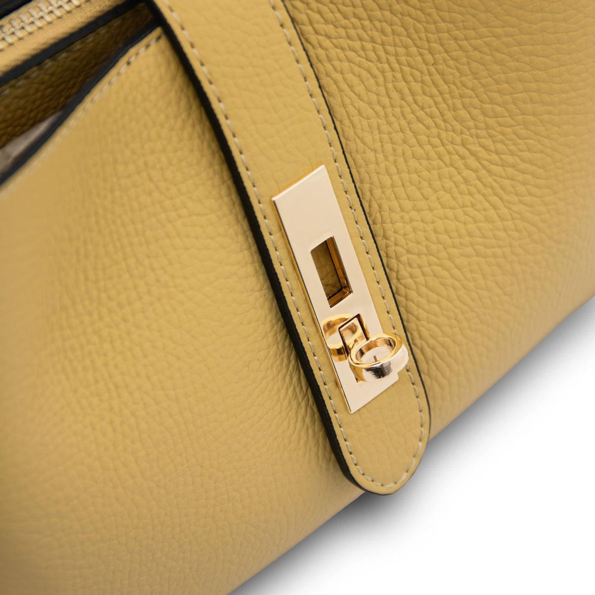 Close up of gold hardware on the mustard leather strap of Soave handbag.