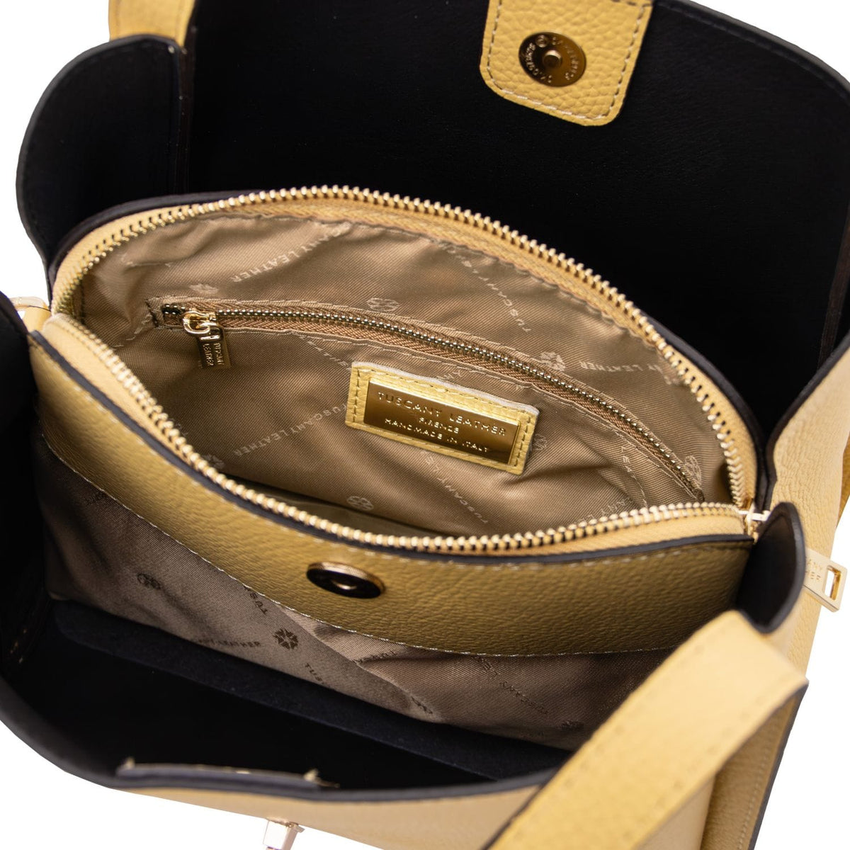 Inside view of Soave handbag with beige lining, zip pocket and brand plate
