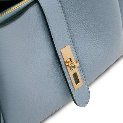 Close-up of pale blue leather with gold hardware and zipper edge on Soave handbag.