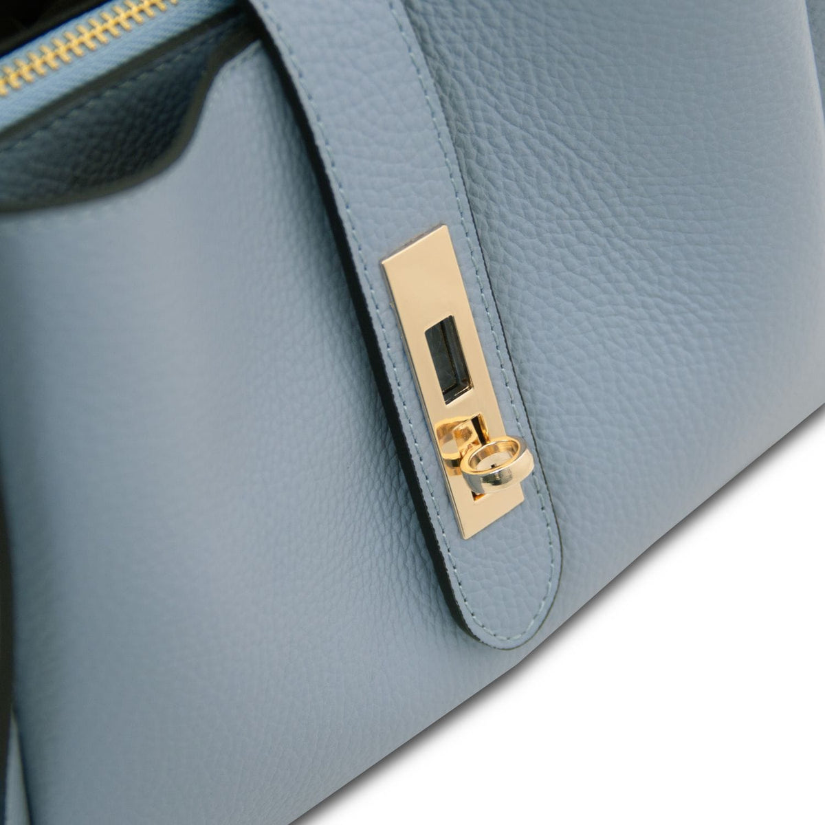 Close-up of pale blue strap with gold hardware on Soave handbag.