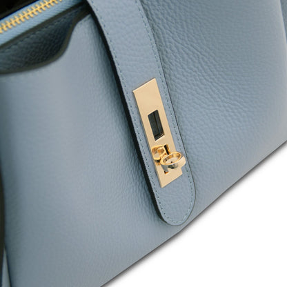 Close-up of pale blue strap with gold hardware on Soave handbag.